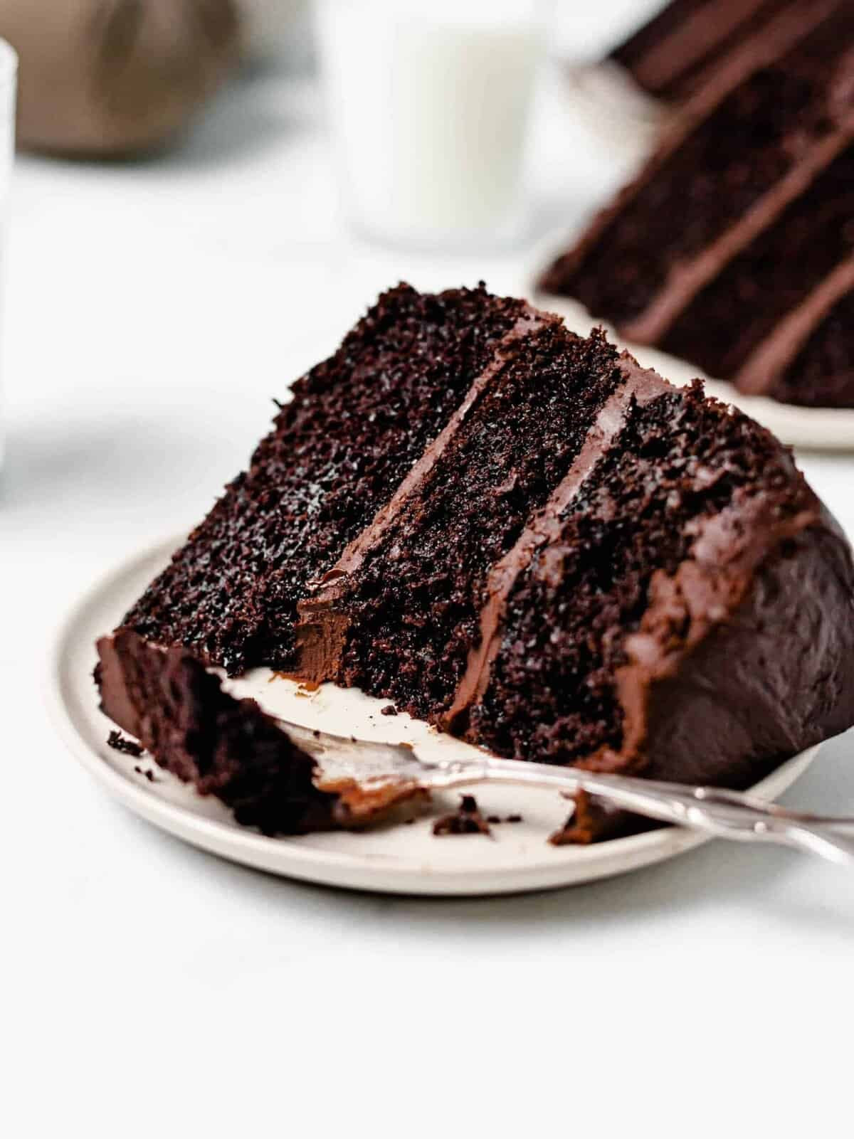 a slice of triple layer chocolate cake with chocolate buttercream icing