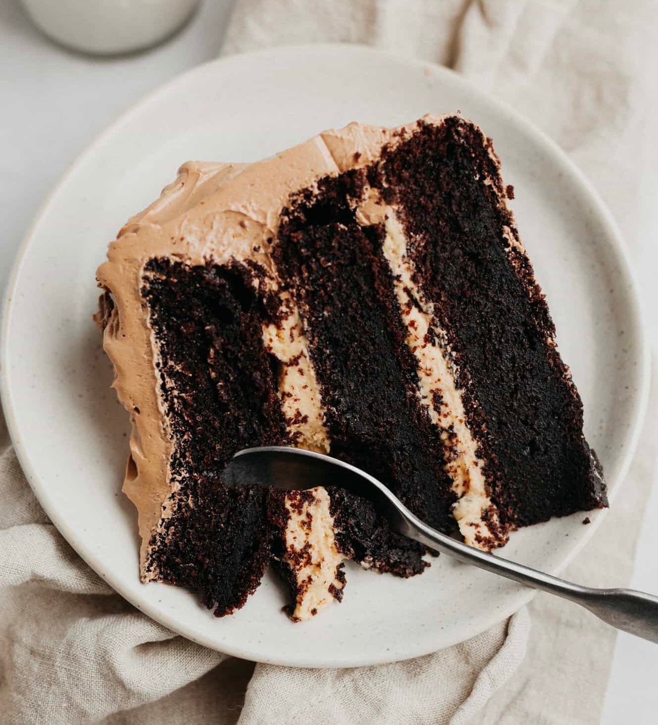 a slice of triple layer cake with peanut butter icing